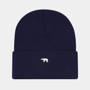 Dettaglio di un berretto in maglia blu scuro con ricamo di orso polare bianco di qualità