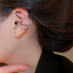 Detail of silver heart ear cuffs set with sparkling cubic zirconia on a model
