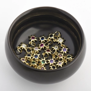 Macro detail of multi-colored zircon star pendants in a black ceramic bowl