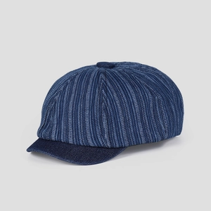 Détail d'une casquette gavroche vintage en jean bleu marine avec texture tissée