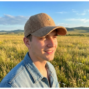 Close-up of brown corduroy herringbone baseball cap featuring a metal crown emblem