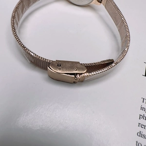 Close-up of rose gold Milanese mesh watch strap with adjustable folding clasp and logo