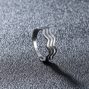 Detail of silver wavy ring with triple-layered 304 stainless steel design on dark surface