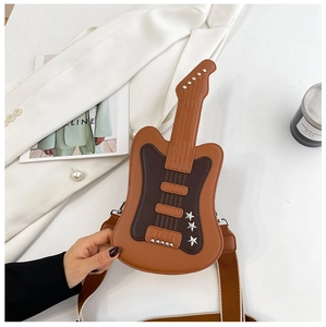 Close-up of guitar-shaped crossbody bag featuring silver star studs and woven strap
