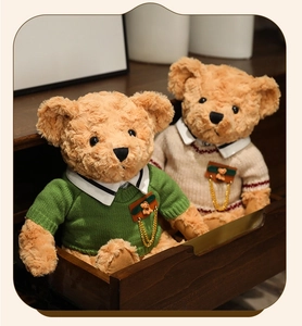 Close-up of teddy bears in knit sweaters with metal chain pendants in a wooden box