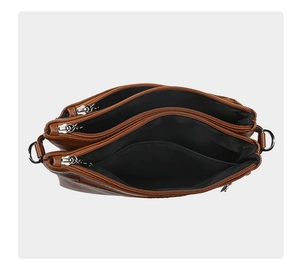 Internal view of brown leather bag with three zippered compartments and black lining