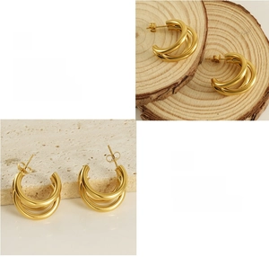 Detail view of gold-plated triple C-shape earrings with high-polish finish and texture