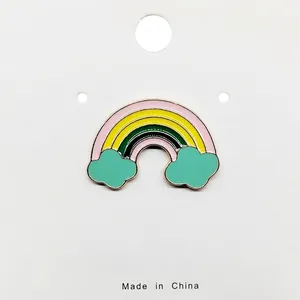 Detailed view of a colorful rainbow enamel brooch with mint green clouds and gold plating