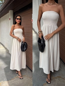 Detail of smocked strapless bodice on a cream maxi dress in a minimalist summer style