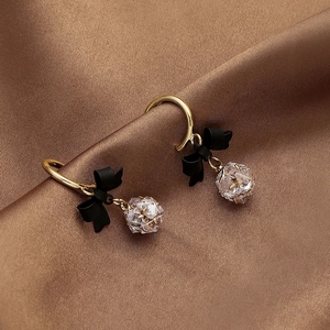 Vintage gold hoop earrings with black bow and faceted crystal drop on brown silk
