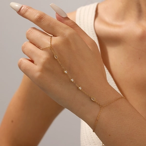 Gold stainless steel finger bracelet with geometric rhinestones and oval ring elements