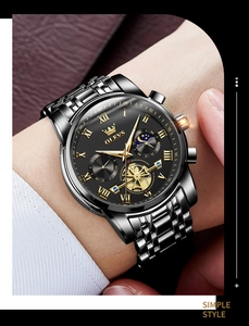 Close-up of OLEVS men's watch featuring a black dial, moon phase, and silver-gold steel band