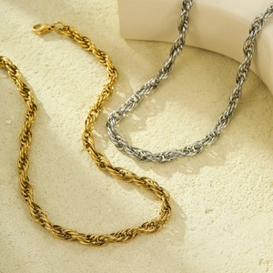 Chic twisted rope chain necklace in gold and silver finish on textured stone background