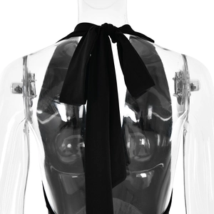 Detail of the back neck-tie ribbon on a black halter maxi dress with backless design