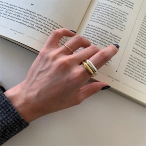 Close-up of three minimalist 925 silver stacked rings on hand with lifestyle background