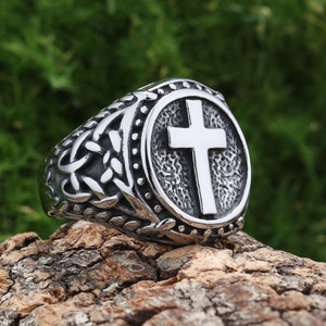 Macro detail of retro stainless steel ring featuring relief cross and Celtic knot motifs