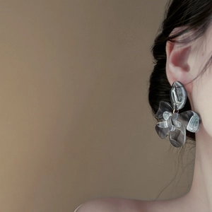 Elegant grey resin flower earrings for women worn by a model in a professional side view