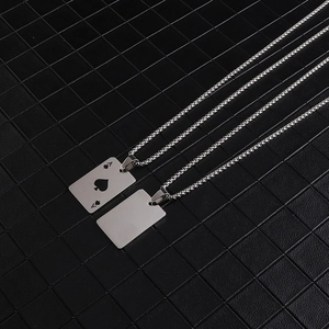 Macro detail of silver stainless steel necklaces with Ace of Spades card pendant