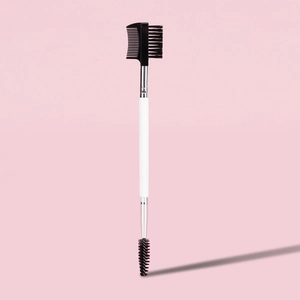 Close-up of double-ended eyebrow spoolie brush and lash comb with white wooden handle