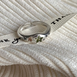 Detailed close-up of a silver adjustable star ring with green and pink stone inlay
