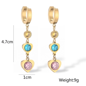 Detailed macro view showing dimensions and weight of gold earrings with heart-shaped gems