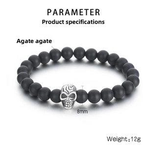 Detail view of 8mm black matte agate beads with silver skull charm on elastic bracelet