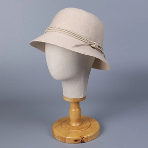 Beige fine knit bucket hat for women with woven rope detail on a wooden display stand