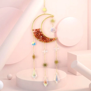 Detail of moon-shaped sun catcher with orange crystals and radiant crystal pendants