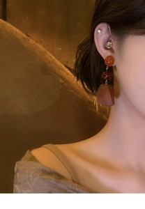 Detail of vintage geometric earrings with wood pendants and resin beads on model