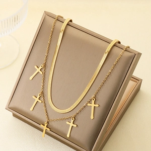 Gold double-layered stainless steel necklace with cross pendants on a jewelry display
