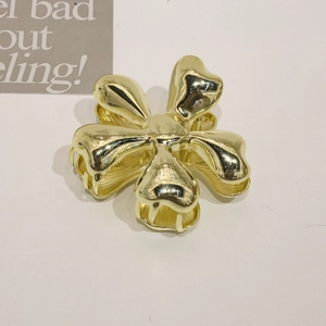 Golden flower-shaped metal hair claw clip for thick hair shown on a white background