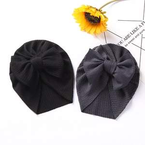 Close-up of black and dark grey waffle-knit baby turbans with large bow details