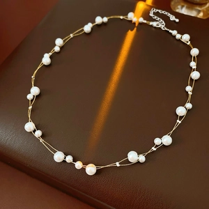 Détail d'un collier de perles élégant à double rangée sur un fond en cuir texturé