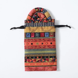 Detailed view of an ethnic pattern fabric drawstring bag with handles for dreadlock bands