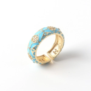 Close-up of 18K gold ring with blue enamel detailing and inlaid cubic zirconia stones