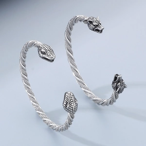 Détail d'un bracelet manchette torsadé vintage avec têtes de loup et de serpent