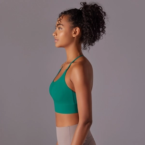 Side view of emerald green cross-back sports bra with soft matte nylon fabric