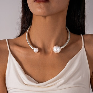 Close-up of metallic pearl choker showing spiral texture and large white pearls