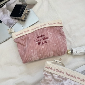 Detailed close-up of velvet makeup bags with Shine Like the Stars heart embroidery