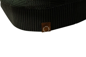 Macro detail of ribbed hem and decorative brand tag on dark knit striped polo shirt