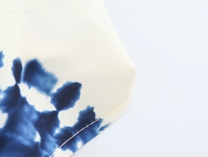 Detailed close-up of geometric print fabric and quality stitching on halter dress