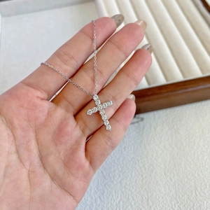 Macro detail of silver cross pendant necklace with sparkling pavé cubic zirconia stones