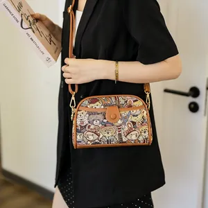 Vintage bear pattern canvas crossbody bag with brown leather trim and metal clasp