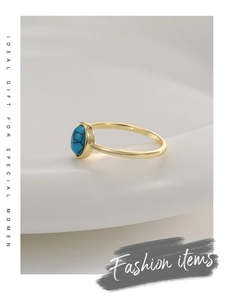 Detailed close-up of a gold ring featuring an oval turquoise stone with natural veins