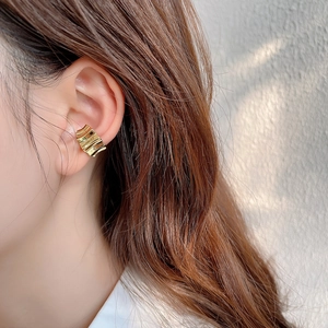 Minimalist gold wavy gear earcuff in 925 sterling silver worn on a female model