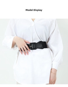 Detail of a black elastic wide waist belt with square buckle on white shirt