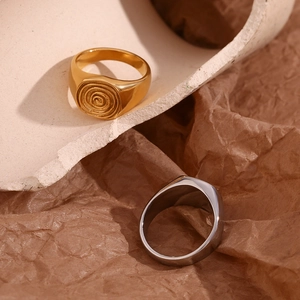 Detailed comparison of gold fingerprint signet ring and silver plain band on stone base