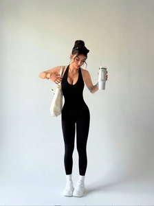 Detail of black halter yoga bodysuit showing deep V-neck and high-stretch seamless fabric