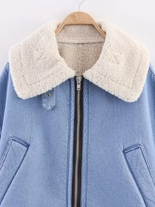 Detail of sherpa-lined collar on light blue denim biker jacket with metal zipper closure