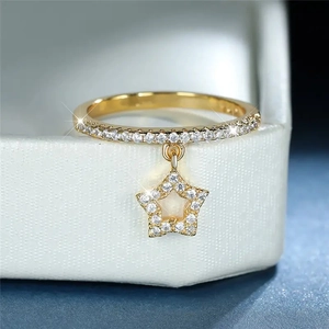 Detail of gold star pendant ring with pavé-set zircons on white leather jewelry box